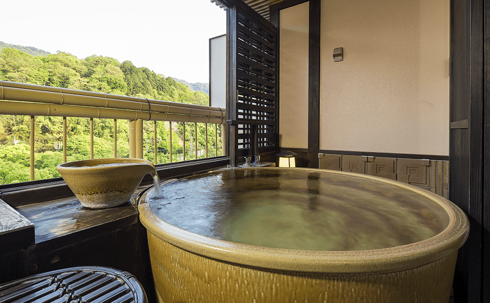 伝統的な民芸品に囲まれた露天風呂。懐かしさを感じる温泉体験