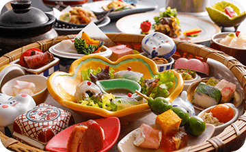 お部屋食で会席料理を楽しむカップル。二人きりの空間で味わう贅沢な食事時間