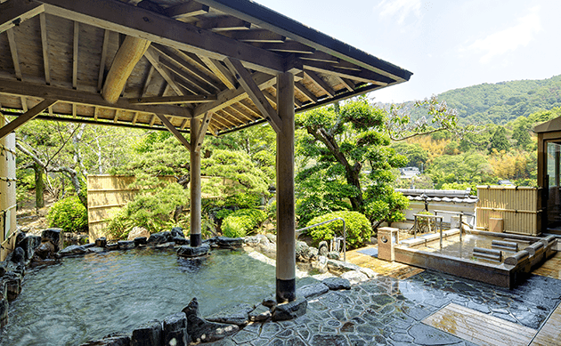 庭園露天風呂でリラックスするカップル。四季の自然を感じながらの温泉体験